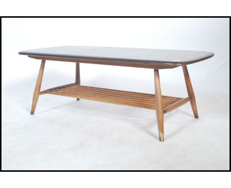 A vintage retro 20th century Ercol gold label low coffee table having a rail bottom raised on tapering legs with panel top. M