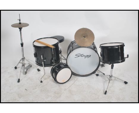 A child's 20th century full drum kit by Stagg to include everything from snare drum to cymbal, stands etc in black and white 