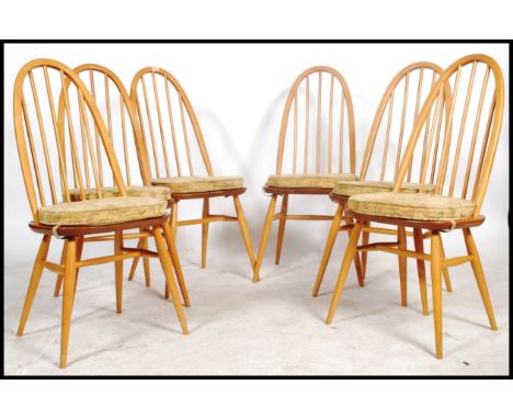 A set of 6 20th century Ercol beech and elm quaker pattern high back dining chairs. Raised on turned legs united by stretcher