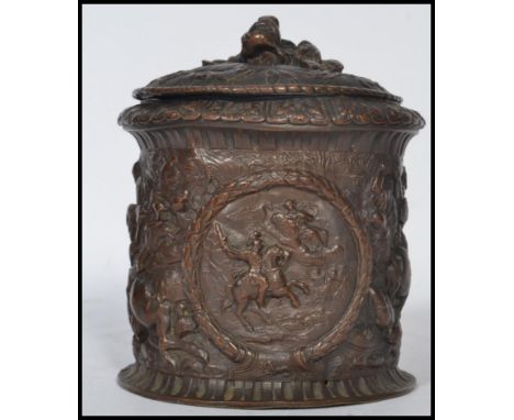 An 19th century Georgian tobacco pot jar. The table top box depicting classical scenes of battle with relief dog finial lid. 