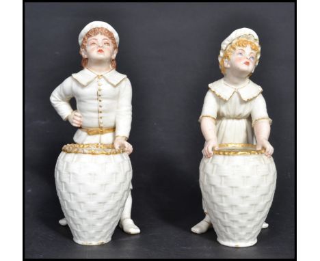 A 19th century Victorian pair of Royal Worcester blush ivory Kate Greenaway figures, modelled as a girl and a boy standing in