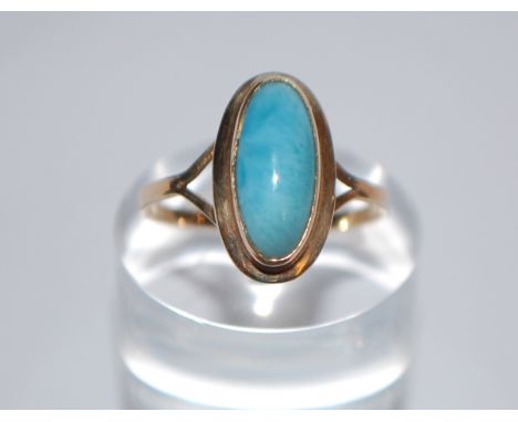 A 14ct gold and blue stone ring being set with an oval cut blue stone cabochon - possibly jade. Marked 14K tests 14ct gold. S