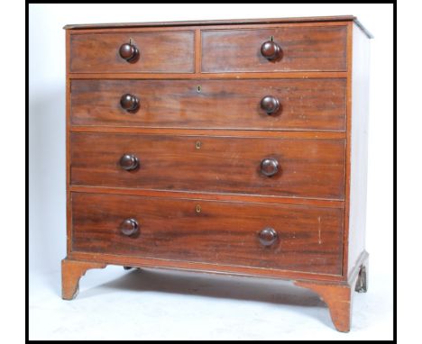 An early 19th century Georgian mahogany chest of drawers raised on bracket feet. The bank of two over three drawers having br
