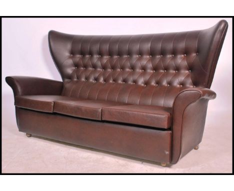 A retro mid 20th century batwing 3 seat sofa settee. In the manner of G-Plan being raised on castors&nbsp; with large oversiz