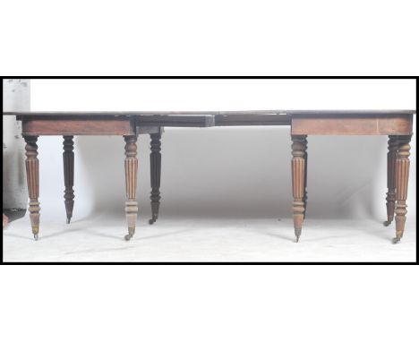 A Georgian 19th century mahogany extending dining table of large form being raised on reeded tapering turned legs with castor