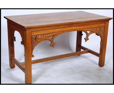 A large 20th century carved oak ecclesiastical communion table. The pugin style table with panelled sides being raised on sti