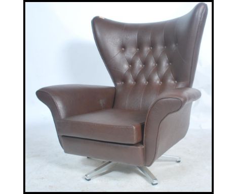 A retro mid 20th century batwing swivel armchair / chair. In the manner of G-Plan being raised on a chrome swivel base with l