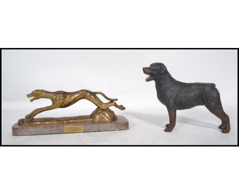 A vintage 20th century painted cast iron figurine of a Rottweiler dog along with a brass figurine of a greyhound on a marble 