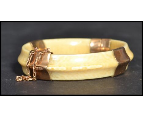 An early 20th century 9ct gold&nbsp; mounted hinged ivory bangle