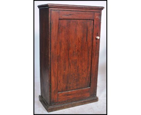 A 19th century Victorian pitch pine hall church cabinet having full length panel door enclosing shelved interior with flared 