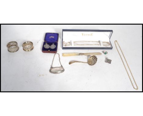 A collection of silver items to include a Victorian silver hallmarked caddy spoon strainer together with a mother of pearl ha