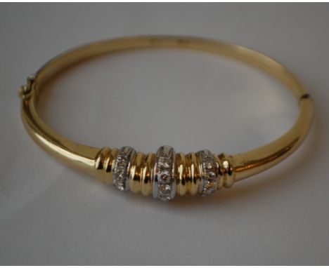 An 18ct gold and diamond bangle bracelet with white gold set round cut diamonds. Diamonds approx 30pts. Marked 18k 750 tests 