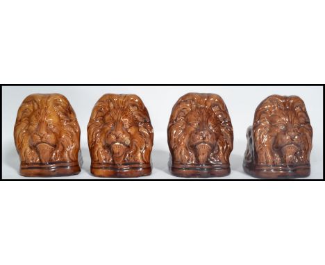 A set of four 19th century ceramic Sash window stays in the form of lion heads having a treacle glaze.