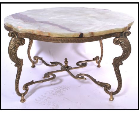 An ornate 20th century shaped onyx topped coffee / centre table supported by a gilt brass stand having a rococo design and ac