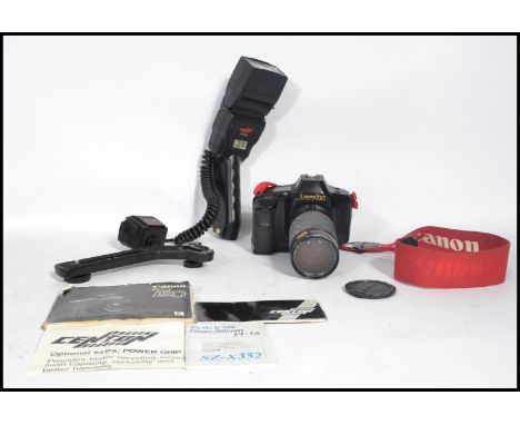 A vintage 20th century Canon T90 35mm camera with a Tokina 35mm - 200mm SX - X352 lens and a Centon FH 95 flash.