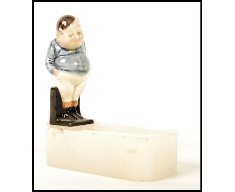 A Royal Doulton figurine pipe holder having a figure of Fat Boy on an onxy base. The base signed Asprey.  Note; from an exten