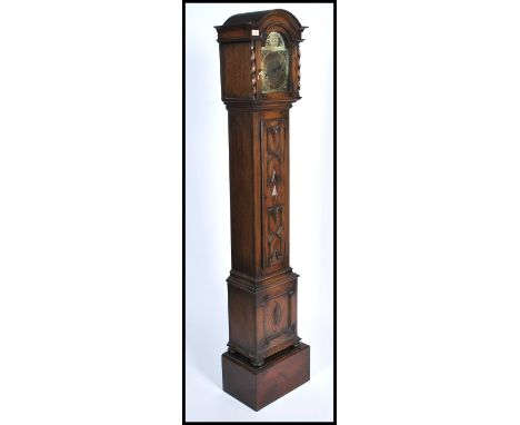 A good quality oak Jacobean revival granddaughter clock having geometric moulded trunk with glass hood housing a brass faced 