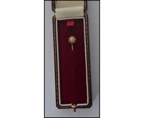 An early 20th century edwardian stick pin having a 9ct gold pin with a diamond set to a 14ct gold mount. Complete in original