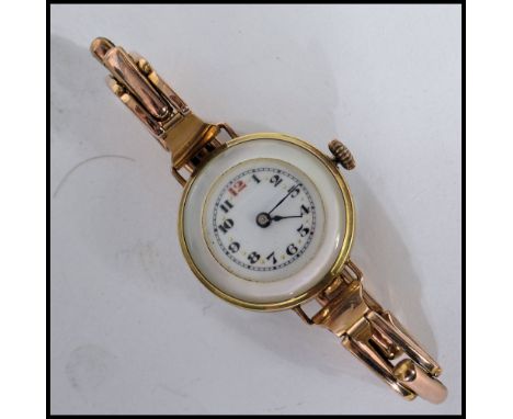 An unusual vintage 20th century yellow metal cocktail watch having a mother of pearl back and case. The white enamel dial hav