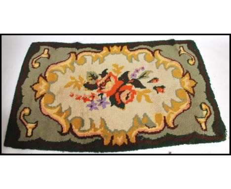 An early 20th century Tibetan floral rug.&nbsp; The green ground with large central medallion of flowers surrounded by decora