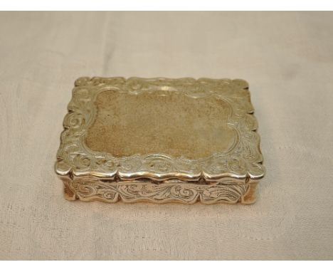 A Victorian silver snuff box having shaped and moulded rims, engraved scroll decoration and plain cartouche, Birmingham 1844,