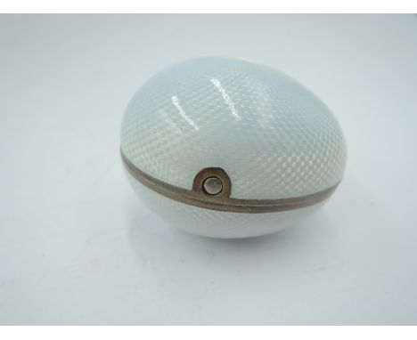 A white metal egg shaped trinket box having white enamelled guilloche decoration with gilt interior, bearing Russian marks, t
