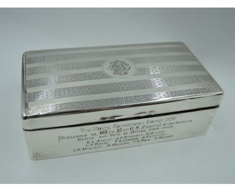 A silver cigarette box of rectangular form having engine turned stripe decoration to lid with monogrammed cartouche and prese