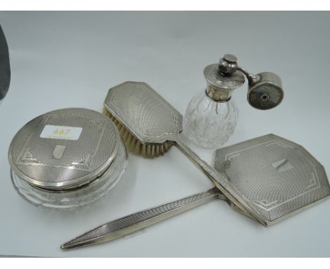 Four silver dressing table items including cut glass perfume atomiser with silver fitments, cut glass powder pot with silver 