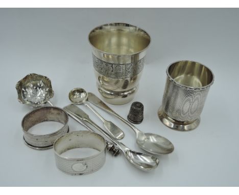 A small selection of HM silver including a beaker having engine turned decoration, two napkin rings, thimble and teaspoon and