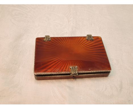 A continental silver card box having tan coloured star burst enamel decoration, gilt interior and marcasite set hinges and cl