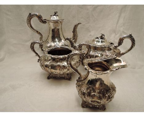 A Victorian Irish silver four piece matched tea set of goad form having extensive repousse and chased floral and leaf decorat