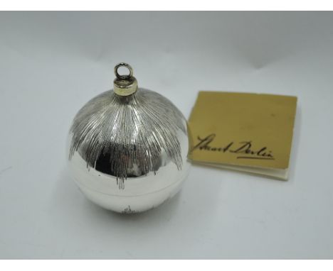 A Stuart Devlin 1983 silver Christmas tree bauble having etched decoration and lift off cover revealing silver and enamelled 