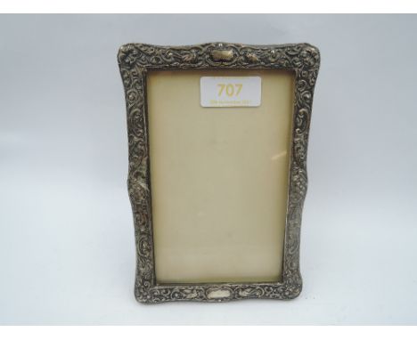 A silver photograph frame having bird and scroll decoration and black velvet easel back, Birmingham 1904, makers mark worn ap