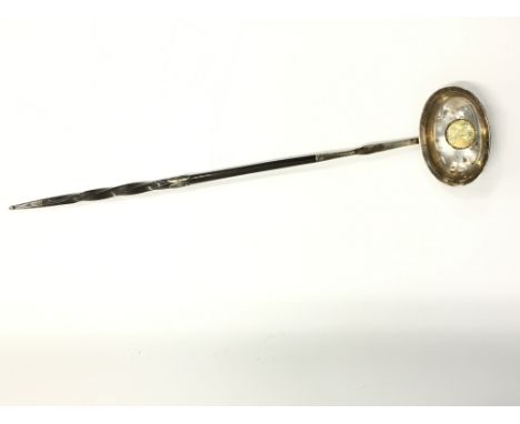 A Georgian silver whalebone handled punch ladle, the bowl inset with a gilded coin.