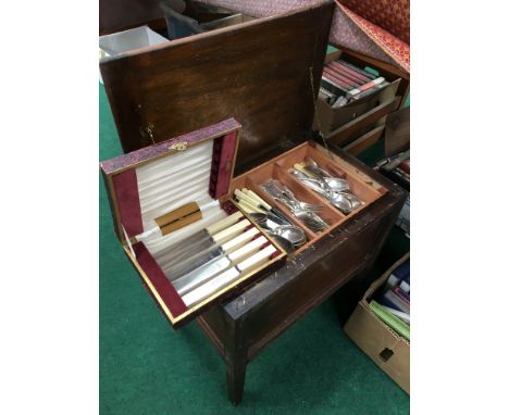 A lift-top mahogany stool containing a quantity of plated cutlery.