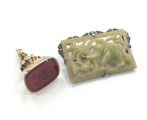 A silver mounted pierced jade effect brooch decorated with an Elephant together with a 19th century gold coloured seal set wi