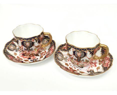 A pair of Royal Crown Derby coffee cans and saucers decorated in an Imari pattern, 383 painted numerals.