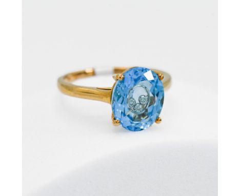 A 9ct yellow gold ring by the designer Glenn Lehhrer set with 4.39 carats of oval cut Swiss blue topaz with three small round