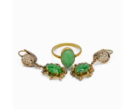 A yellow gold ring set with an oval cabochon cut jade measuring approx. 13mm x 8.5mm x 6mm, Asian hallmark on outside of shan