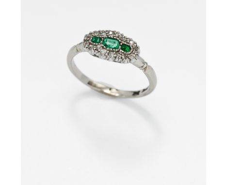 An antique 18ct white gold &amp; platinum ring set with three central emerald cut emeralds surrounded by small old round cut 