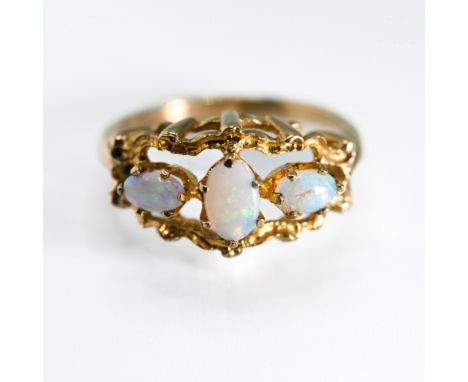 A 9ct yellow gold ornate open design ring set with three oval cabochon cut opals, the centre opal measures approx. 6mm x 4mm 