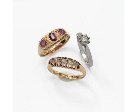 An 18ct yellow gold 'gypsy' style ring set with three oval cut garnets, 2.82gm, size O 1/2, a platinum ring set with a round 