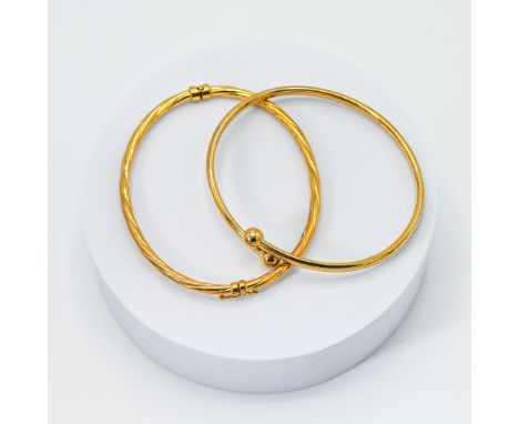 A yellow gold torque style bangle, 4.37gm and a yellow gold twisted design bangle, 3.45gm, (not hallmarked or tested), (2).