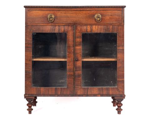 A Regency rosewood side cabinet, early 19th century; the top with bobbin-turned edging, above a drawer with gilt metal ring h