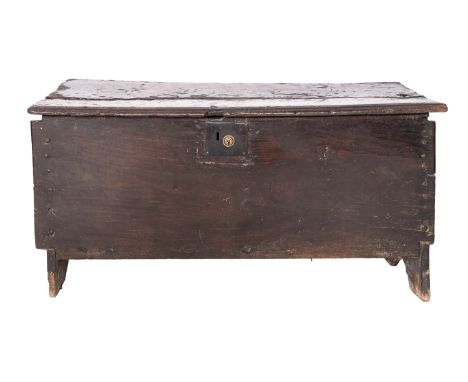 A Jacobean oak coffer, first half 17th century; the hinged cover with channeled front and back edges and notched ends; the en