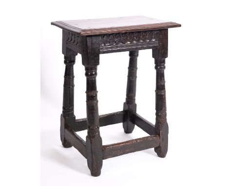 A Jacobean oak joint stool, elements 17th century and later; the seat with moulded edges above chip carved friezes, on knop a