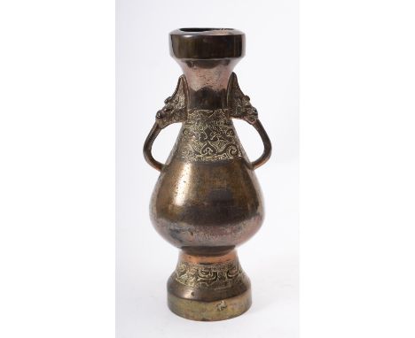 A Chinese bronze two-handled vase in archaic style of baluster form cast with bands of taotie masks and scrollwork, leaf mark
