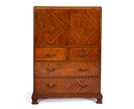 A mahogany chest in 18th century style, mid 20th century; with quarter veneered doors opening to shelves; above two short and