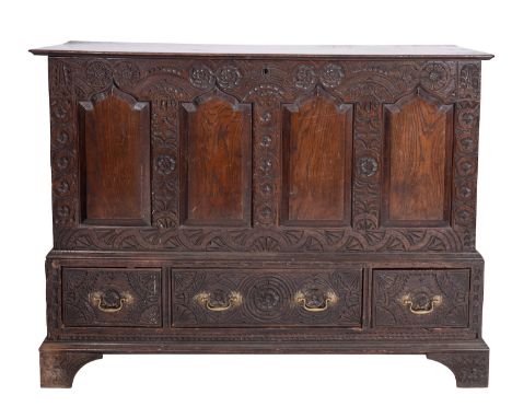 An oak mule chest, elements early 18th century and later; the hinged top above four shallow Gothic arched panels with relief 