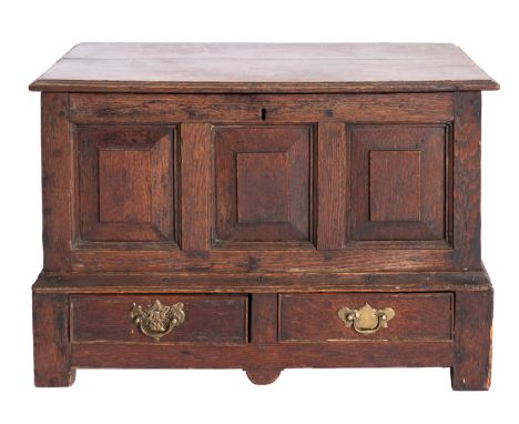 A George I oak coffer bach, early 18th century; the hinged top with moulded edges; the front with three panels above two shor